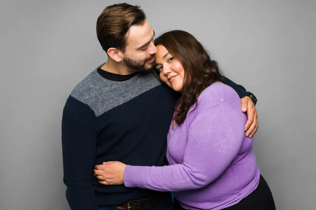 Smiling couple embracing each other happily.