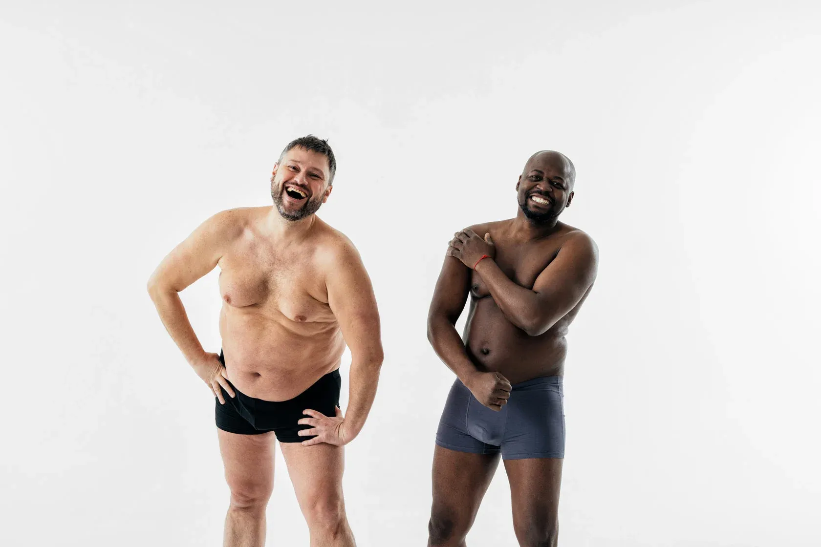 Two joyful men in underwear smiling together.