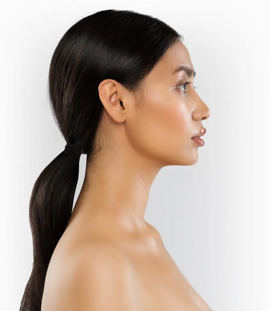 Profile of woman with ponytail and clear skin.