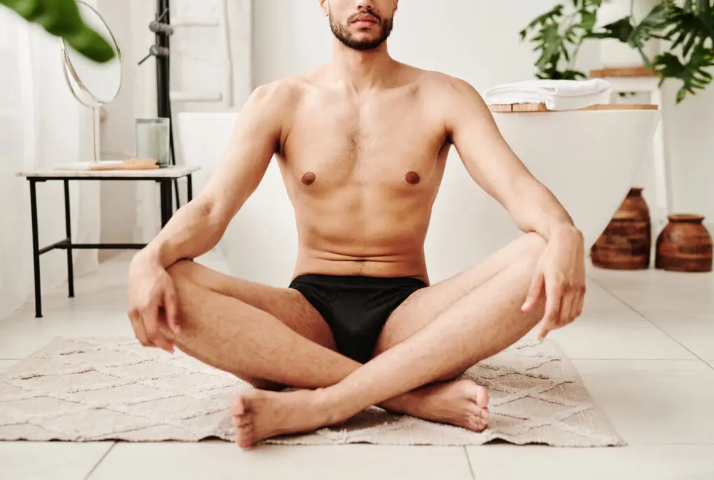 Man meditating in modern bathroom setting