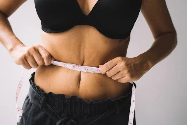 A woman measuring her waist