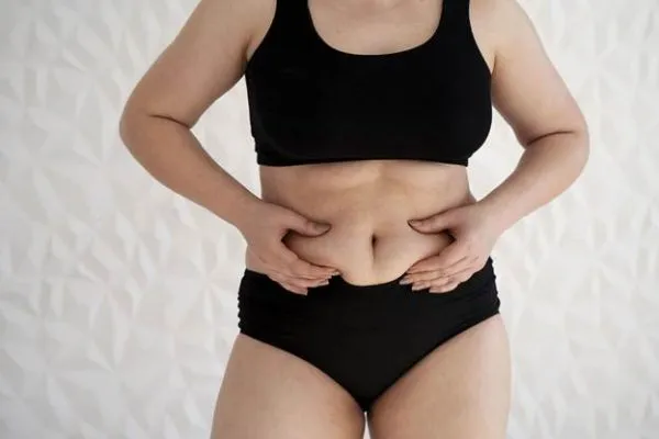 A woman in black lingerie thinking about tummy tuck surgery