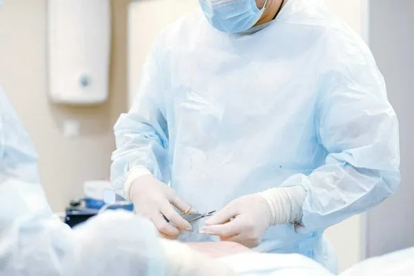A plastic surgeon doing an abdominoplasty with his assistant