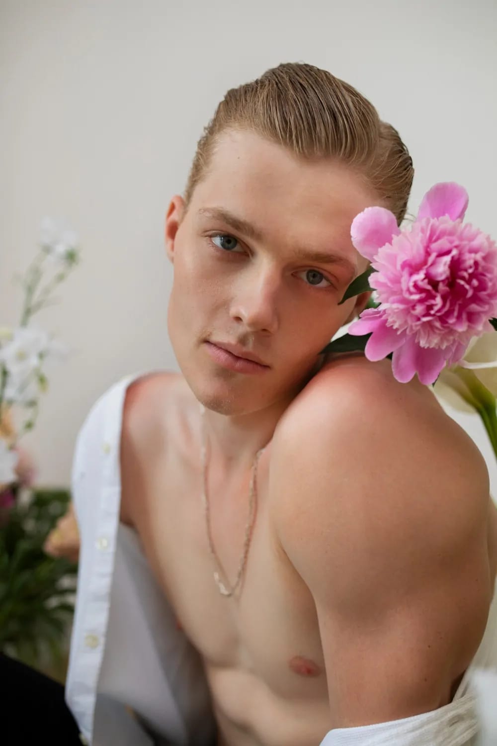 Side view smiley man posing with flowers after plastic surgery recovery