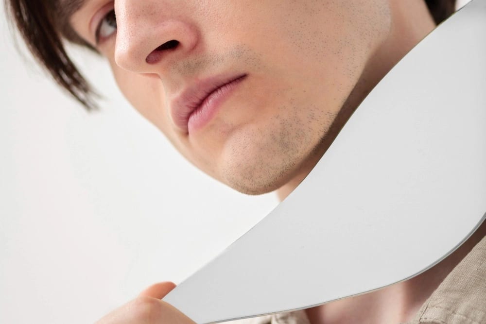 Side view man posing with mirror piece