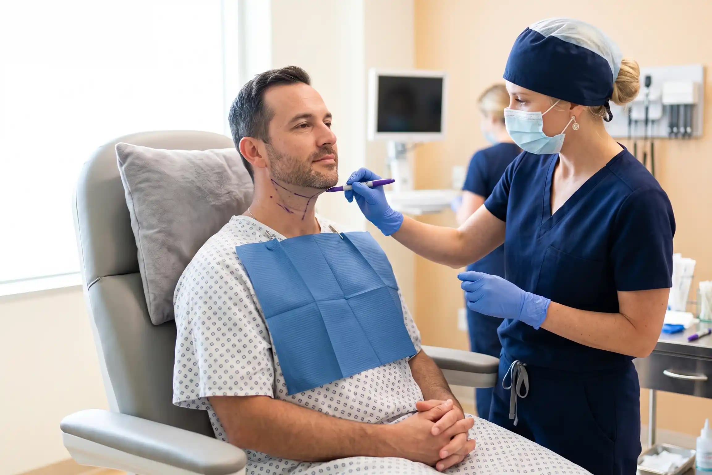 Surgeon marking neck contours on an awake patient before neck liposuction